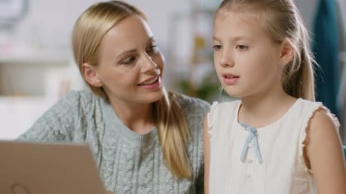 Bright Little Girl Studies with Her Lovely Young Mother Study School Lessons at Home. Dedicated Mom