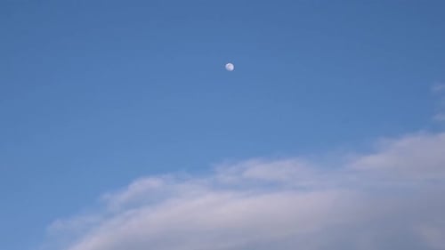 Clear Moon Shines in Blue Sky with Clouds