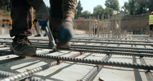 Bauarbeiter webt Stahlverstärkung auf der Baustelle