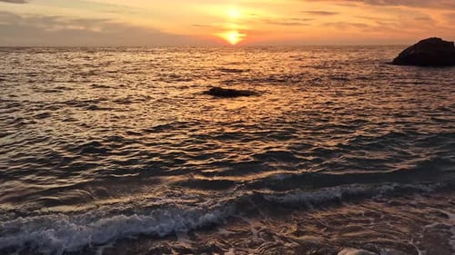 Sunset Ocean Waves Golden Light Reflecting on Tranquil Water Surface During Stunning Beach Evening