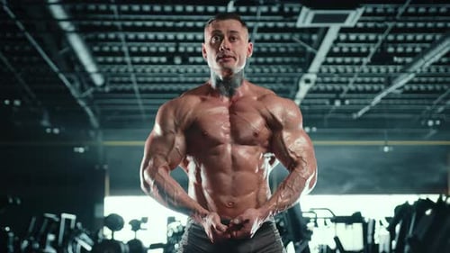 Man with Large Muscles Posing in Gym
