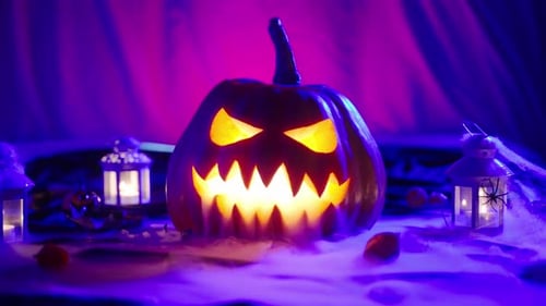 Glowing Halloween Pumpkin Next to Spooky Lanterns