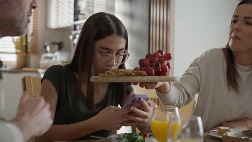 Family at the Table with Teen on Phone