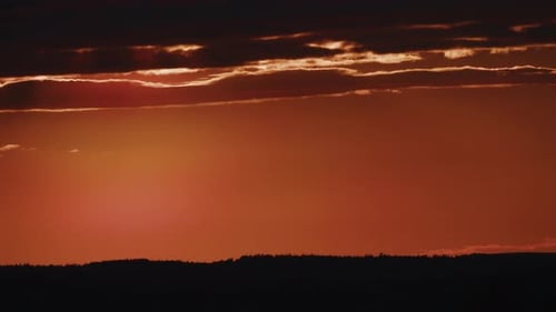 Zeitraffer des Himmels nach Sonnenuntergang mit Wolken und orangefarbenem Himmel