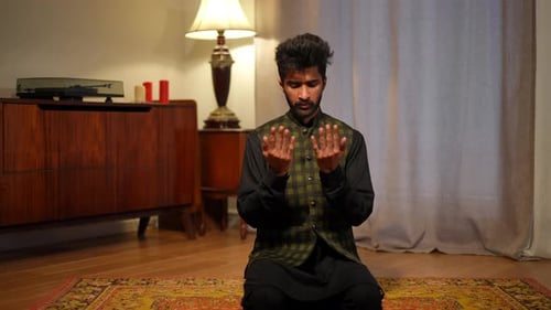 Wide Shot Concentrated Muslim Man Praying on Knees in Living Room As Live Camera Zoom in Front View