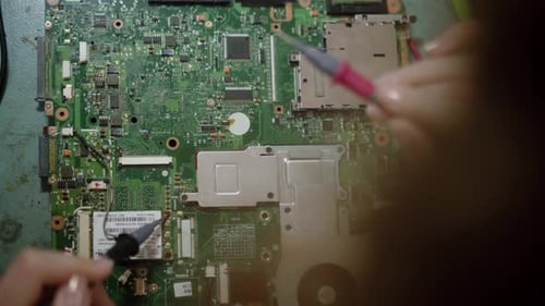 Electronic Repair Service Center Worker Repairing Computer Boards Closeup of Female Hands Testing