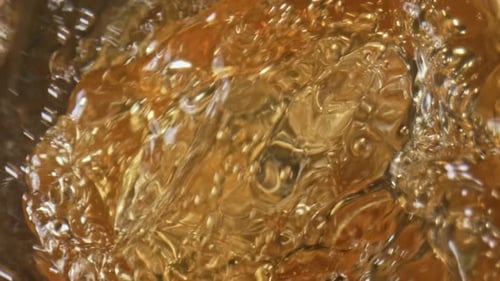 Golden Ale Jet Inside Glassware Closeup. Refreshing Effervescing Beer Stream Swashing Macro