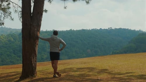 Man Leans on Tree Overlooking Green Mountain Valley