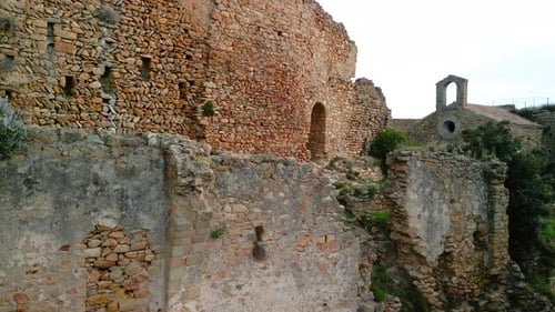 Ruined castle in Europe aerial footage cinematic medieval era Brick wall closeup to small church in