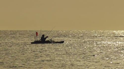Mujer pescando desde una silueta de kayak de mar, estilo de vida activo, Cámara lenta