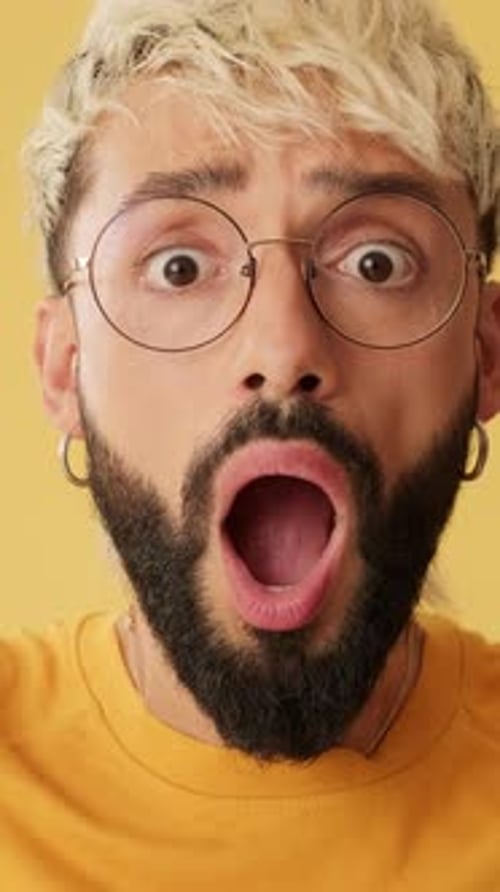 Man Reacting with Surprise Against Yellow Background
