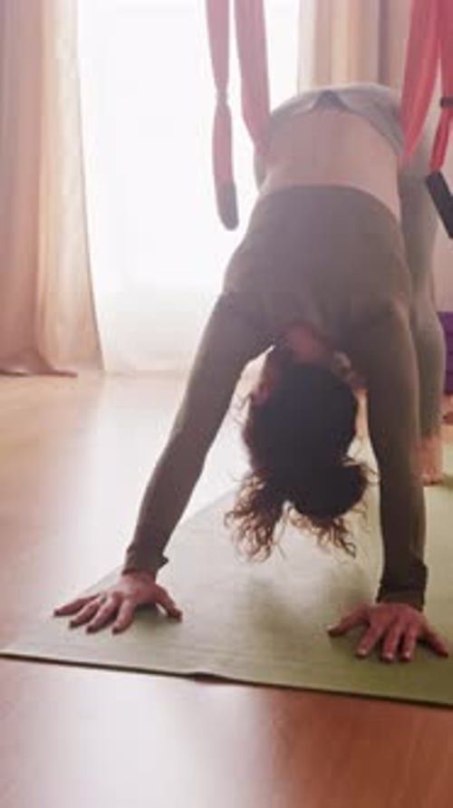 Femme pratiquant le yoga aérien vinyasa avec hamac