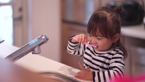 Girl Brushing Teeth in Bathroom