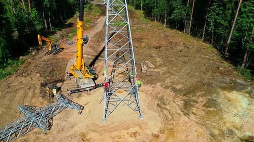 Workers working on electrical tower for electricity supply in rural area. Construction site into for