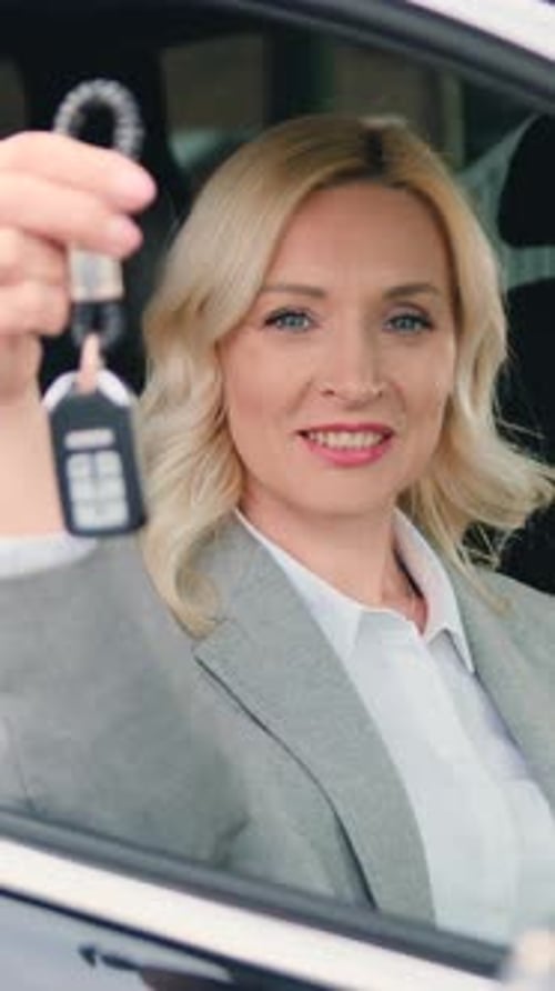 Smiling Woman Holding Car Keys in Vehicle