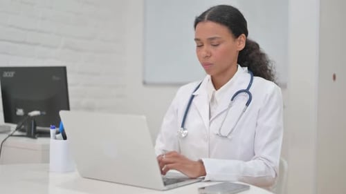 African Female Doctor Smiling at Camera in Clinic