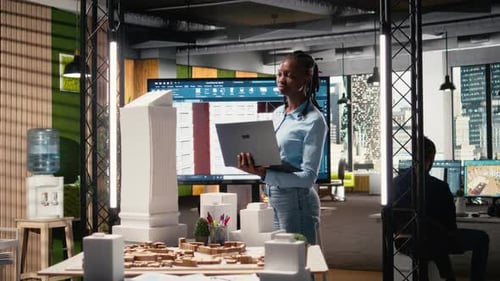 Black Female Developer Reviewing Zoning Regulations with 3D Models