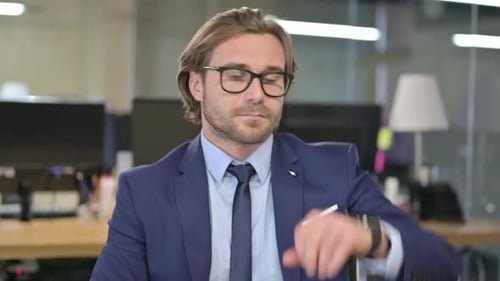 Adult Looking at Watch in Office