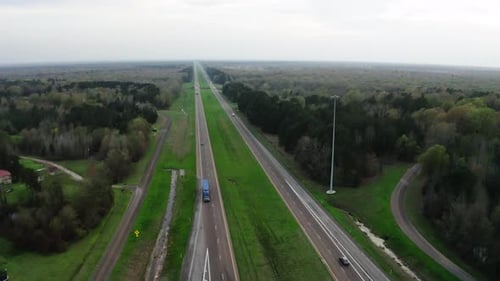 Semi trucks driving on American style highway in high angle drone view