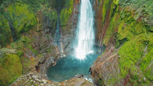 Scenic Blue Lagoon and Surrounding Rocks Beneath Waterfall in Tropical Costa Rica Jungle
