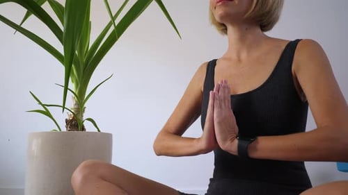 Woman Meditating in Yoga Position Indoors