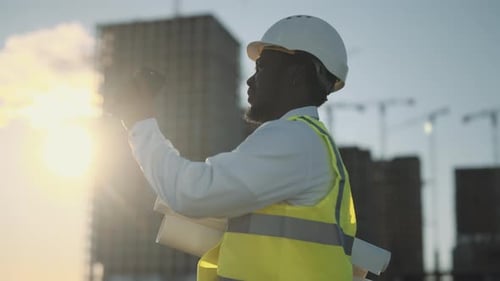 Serious Foreman Using Smartphone in Construction Site Send Message in Work Chat Engineer or
