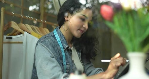 Woman Designs Fashion with Tablet at Workplace