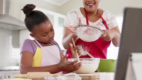 Mother and Daughter Baking Together in Kitchen