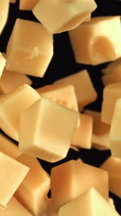 Maasdam Cheese Flies Up and Falls Down on a Black Background Filmed on a Highspeed Camera at 1000
