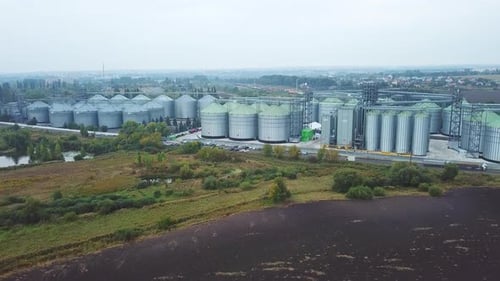 Numerous metal elevator tanks at the territory of modern granary plant.
