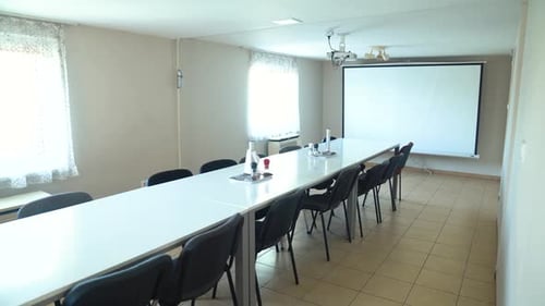 Empty Meeting Room with Long Table and Screen