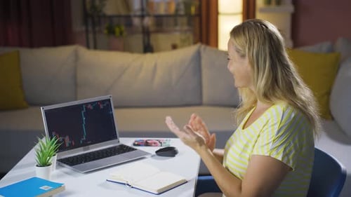 Investor looking at the stock market chart. She claps when she wins.