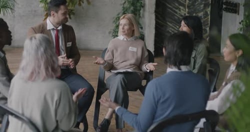 Therapist and Patients Sitting in Circle Holding Hands and Talking Enjoying Group Session in