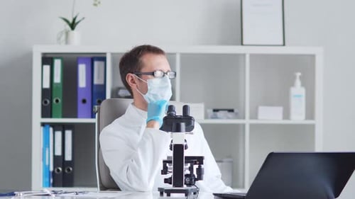 Scientist Using Microscope in Medical Laboratory