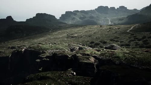 A Mountain Range with Rocks and Grass in the Foreground Mountain Path