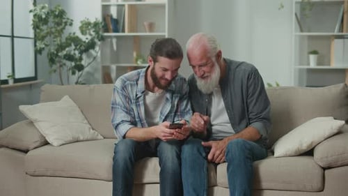 Young Adult and Senior Using a Smartphone Indoors
