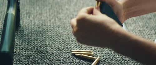 Close View of Bullets Being Inserted Into Rifle Magazine During Loading Process