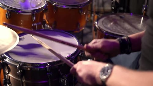 drummer enthusiastically rhythmically hits the drum kit. plays a song during live performance