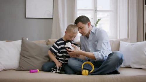 Father and Son Playing with VR Headset at Home