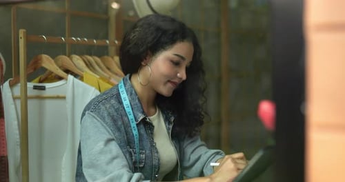Fashion Designer Drawing Designs in Studio