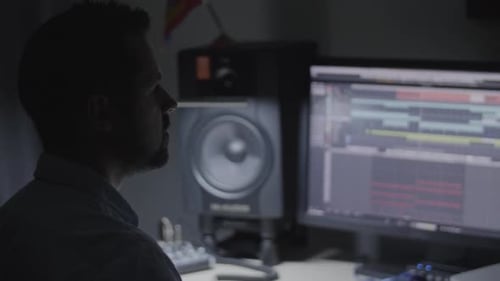 Producer, Sound engineer, musician checking the sound mix in his studio and reacting to the music gr