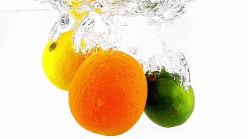 Citrus Fruits Dropping into Water with Splash