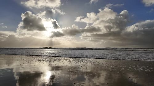 Beach scene. Wave arriving calmly on sand at sunset. Static, low POV