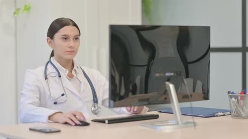 Young Female Doctor Smiling at Camera at Work in Clinic