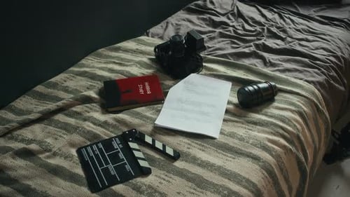 Filmausrüstung und Drehbuch auf dem Bett