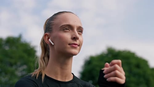 Woman with Wireless Earbuds Outside in Nature