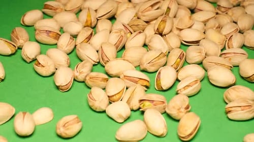 Pistachio Nuts on a Green Background Ripe Salted Pistachios Close Up