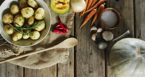Overhead view of cooked potatoes and multiple food ingredients on wooden surface