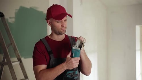 Construction Worker Checking Angle Grinder Disc During Renovation
