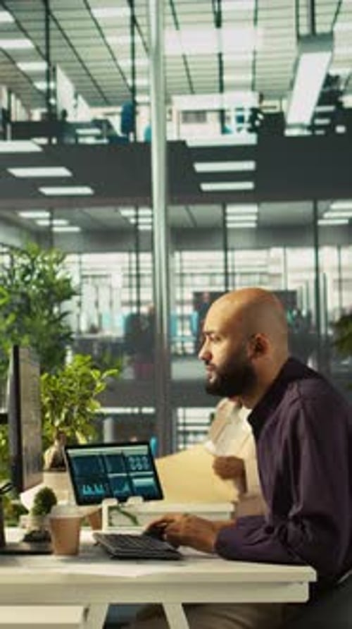 Vertical Video Man in Office Reviewing Financial Graphs Analyzing KPIs